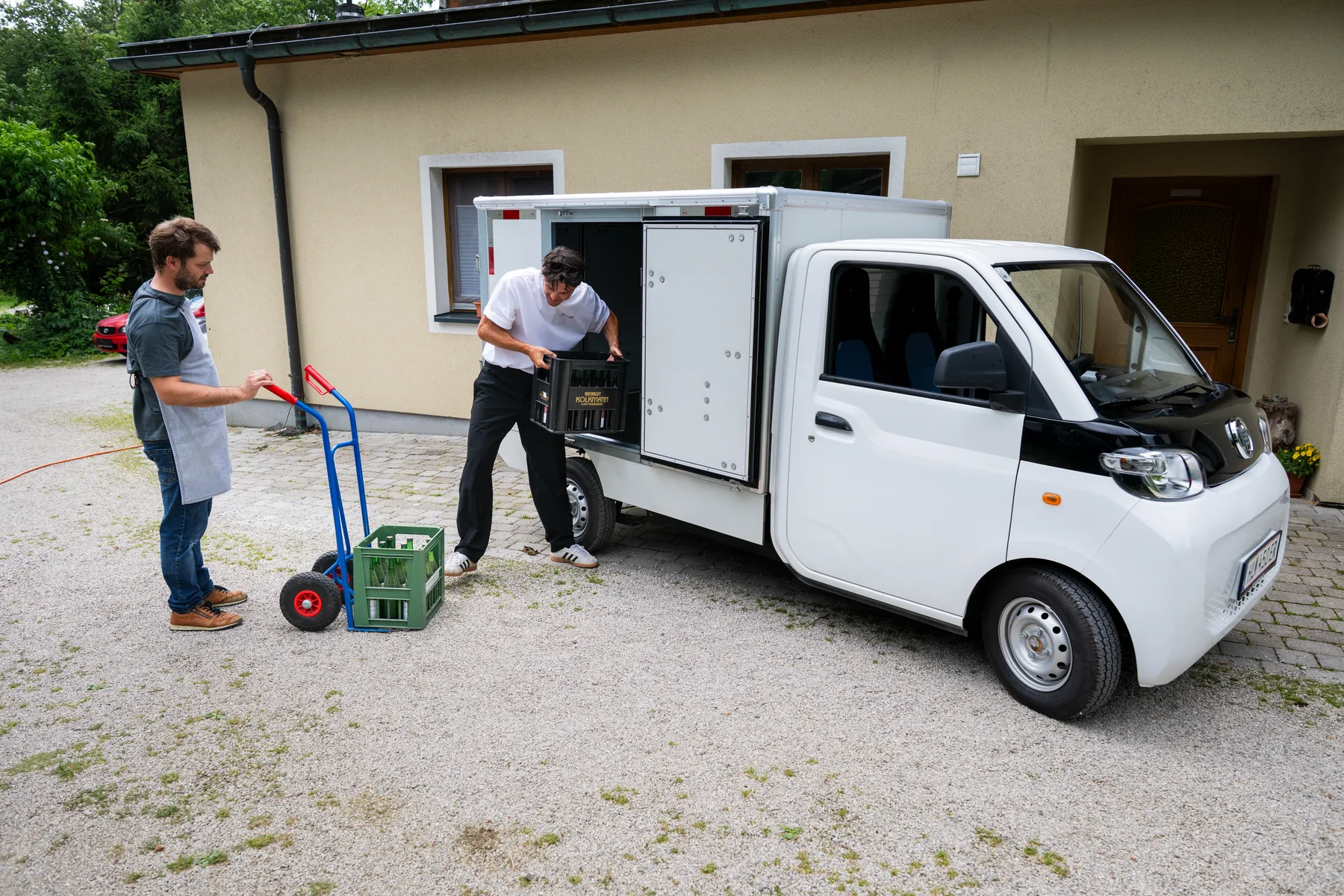 Zwei Männer beladen den eVOXX Cargo mit einer Sackkarre
